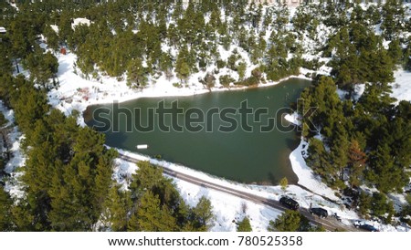 Aerial drone bird's eye photo of famous Lake Beletsi covered with snow at winter time, Ipokrateios politeia, Parnitha, Attica, Greece  