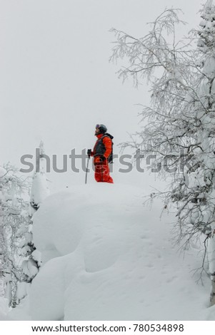 Man standing at top of ridge. Ski touring in mountains. Adventure winter freeride extreme sport.