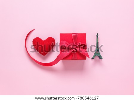 Table top view aerial image of sign valentine's day background concept.Red heart & beautiful gift box and metal Eiffel Tower model.Object on modern rustic pink wall paper at home studio office desk.