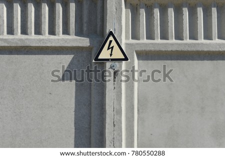 sign of high voltage on the concrete fence of the electrical substation
