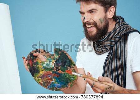 Laughing artist in hand Palette looking at canvas with pattern on pink background, art                