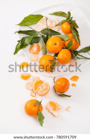 Fresh tangerines with leaves and peeled tangerines, sliced with peel. The beneficial properties of mandarins for health.