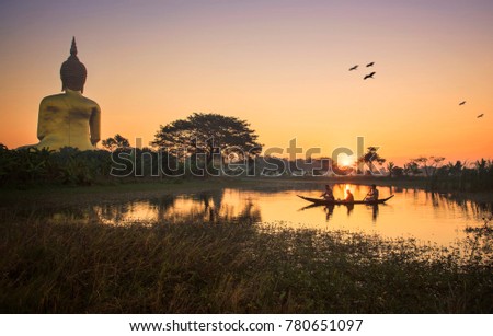 Backside view of golden big buddha statue with sunrise background at Wat Muang, Ang Thong Province, Thailand