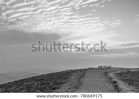 White and black landscape of middle east amazing morning sky. Beautiful sunrise in negev desert in Israel. Warm orange sunlight and sunny cloudy background. Nobody on photo, tourism season.