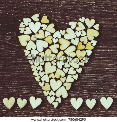Decorative heart on a wooden background. Festive background with decorative wooden hearts.