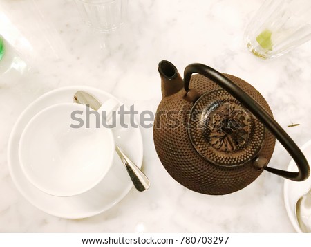 Tea pot and cup on a marble table background hot drink flat lay