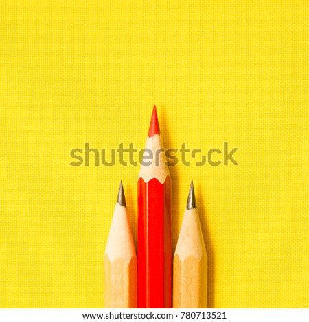 Red pencil and simple pencils on a yellow background