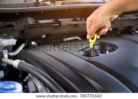 Hand of car mechanic check engine oil for maintenance . Royalty-Free Stock Photo #780731602