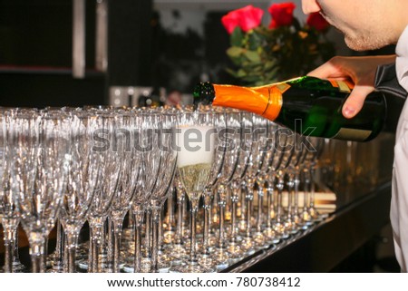the waiter pours champagne by the glass at a gala event at the r