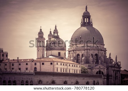 Basilica di Santa Maria della Salute on the Grand Canal, Venice, Italy. Historical architecture and cityscape of Venice. View of the famous old cathedral in Venice. The vintage photo of church domes.