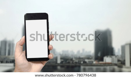 Mock up image of hand holding black smartphone with blank white screen on blurred Bangkok city background. Concept for display your design.
