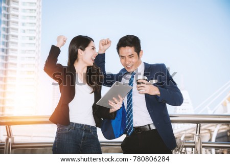 Happy success wow business woman and business man, business people happy When Looking at the tablet