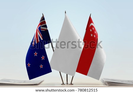 Flags of New Zealand and Singapore with a white flag in the middle