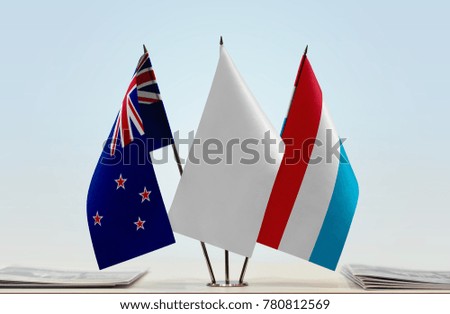 Flags of New Zealand and Luxembourg with a white flag in the middle