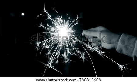 Sparkler background / A sparkler is a type of hand-held firework that burns slowly while emitting colored flames, sparks, and other effects