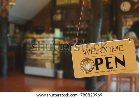 Wooden sign board hanging on door of cafe