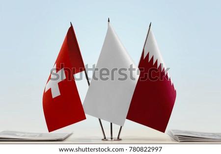Flags of Switzerland and Qatar with a white flag in the middle