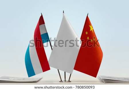 Flags of Luxembourg and China with a white flag in the middle