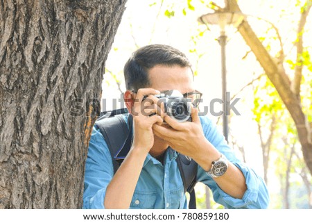 a man or tourist or photographer take a photo and travel in nature park with tree and sunlight background