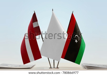 Flags of Latvia and Libya with a white flag in the middle