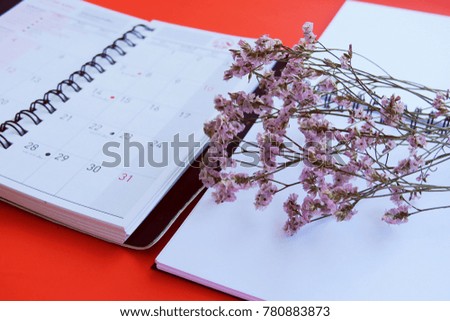 Concept of business desk top view with diary planning and flower closeup background