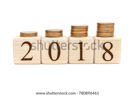 Stacks of coins on wooden cubes with numbers 2018. 