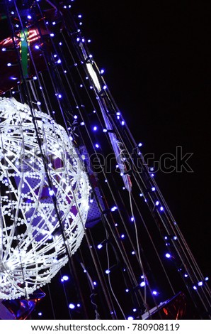 Fragment of the New Year tree. A lot of round lights of blue color are located on a conical frame