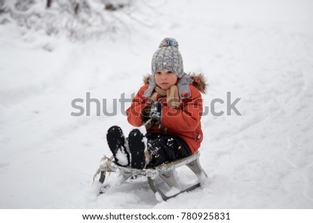 winter fun. the boy is riding a sled