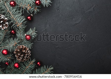 Evergreen tree handmade toys, snowflakes, red globes and fir branch on black stone background, view from top, above, Xmas greeting card with space for text wish Royalty-Free Stock Photo #780956416