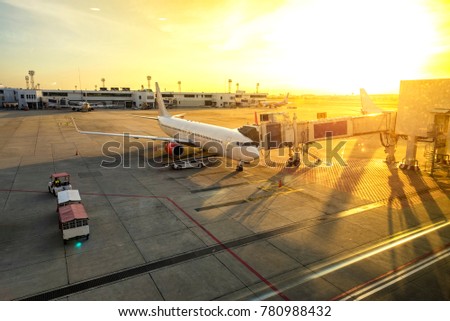 Airplane at the terminal gate ready for takeoff at international airport during sunrise, travel concept