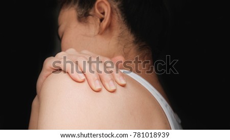 woman with shoulder pain .Acute pain in a woman muscle. Concept photo with read spot indicating location of the pain.
