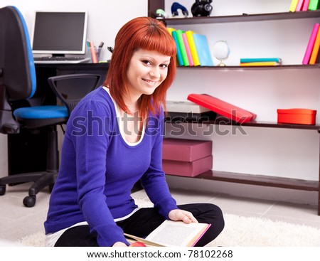 teenager girl reading book on floor in room