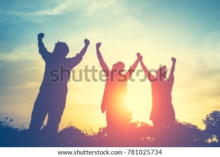 Silhouette of Happy family standing in field on sunset and holding hands