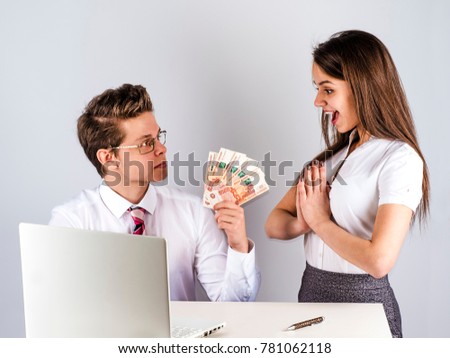 The concept of gratitude. A young handsome man gives money to a beautiful insurance agent. Gray background.