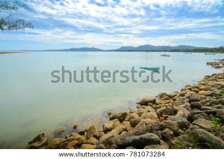 Rock beach and blue sky with beautiful clouds tropical sea, Rocks shore at natural bay in the morning. 