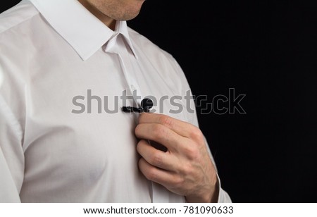 A man puts on lavalier microphone, preparation for interview