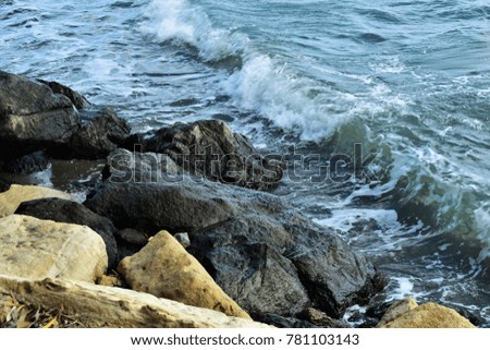 Sea rocks and rolling wave, nature image.
