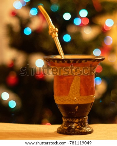 Tradicional brazilian cup and straw for drinking yerba mate tea and the christmas tree on background
