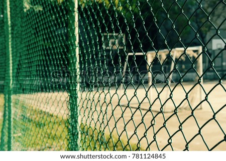 a view through a fence of football goal. this image has selective focusing.