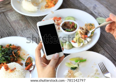 Hand holding smartphone in restaurant, Communication technology concept