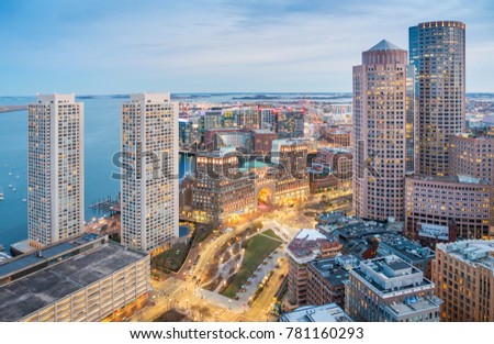 Aerial view of Boston in Massachusetts, USA at night showcasing the skyscrapers of the Boston Harbor and Financial District.