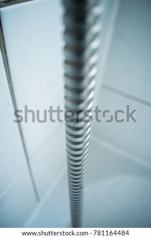 Metal shiny shower hose tube in clean sterile environment bathroom hospital