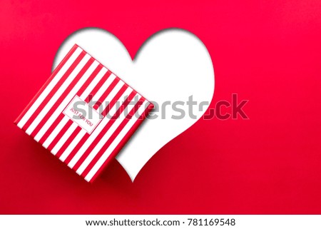 A fancy gift box and big heart space on red paper background 
