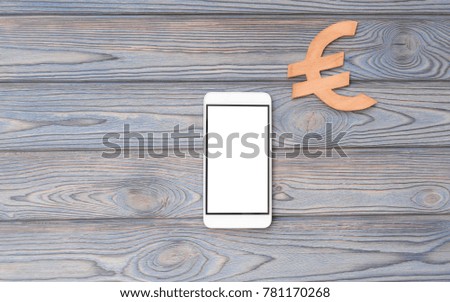 smartphone, euro sign on the background of a wooden table