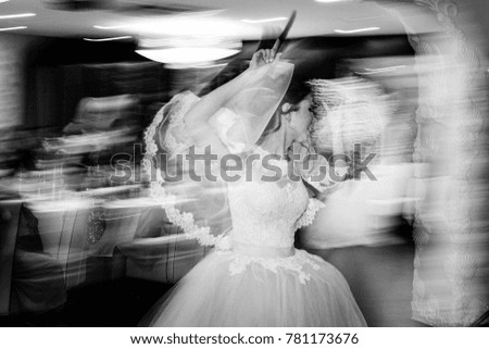 Wedding banquet. The bride is dancing in a pink dress. Black and white photo