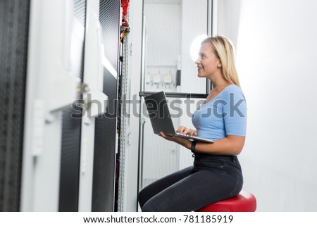 Portrait of technician working on laptop in server room
