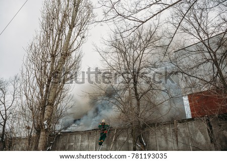 Fire in an industrial warehouse or Factory on Lantenskaya Street in Voronezh, rubber is burning, lots of smoke and flames, firefighters and MES rescue workers are struggling with a fire
