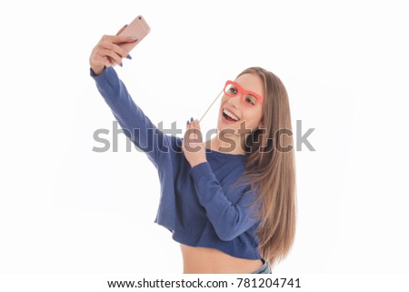 Beauty funny teenage girl with paper glasses on stick making selfie with her cellphone