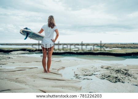 Woman Standing on Sea Shore With Surfboard