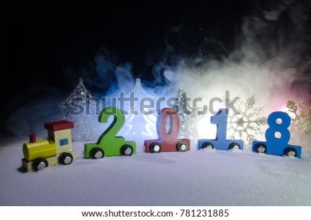 2018 happy new year,wooden toy train carrying numbers of 2018 year on snow. Toy train with 2018. Copy space. Christmas decoration. Selective focus. Dark background